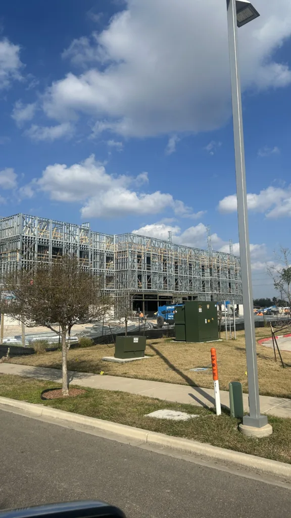 image00030 - Scottsdale Construction Systems Under-construction multi-story steel frame building with exposed metal framework against a blue sky with clouds.